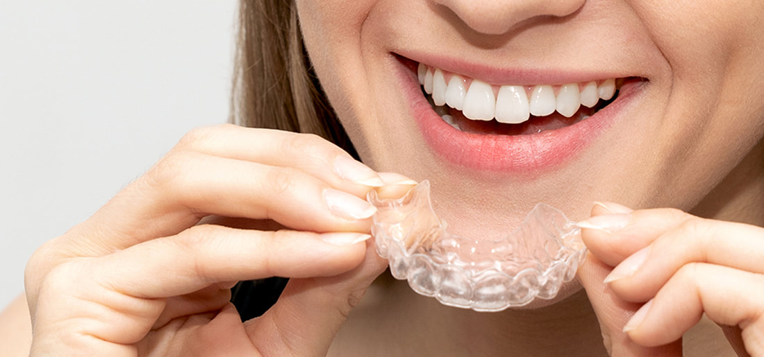 Woman holding invisalign to resolve most teeth-straightening and bite problems.